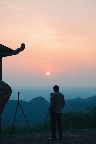 human men standing in a hill during daytime tripod