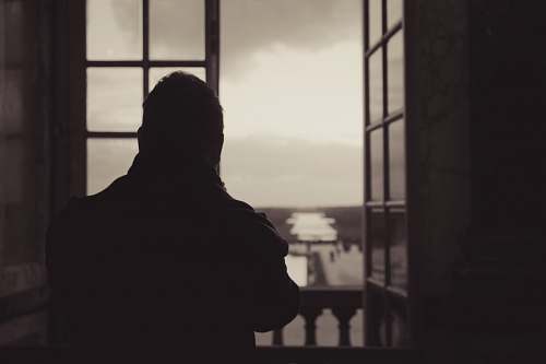 human person standing near open glass window silhouette