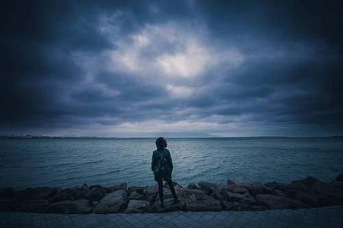 sea person standing near seashore sky