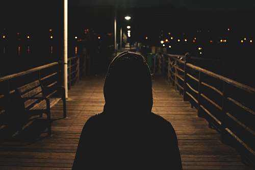 human person wearing hooded jacket walking in bridge people