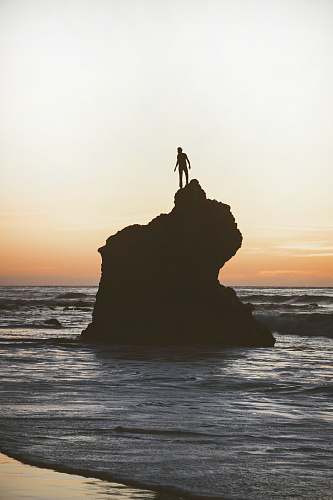 standing silhouette of a man on a rock human
