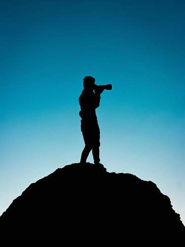 human silhouette of person holding telescope graphic standing