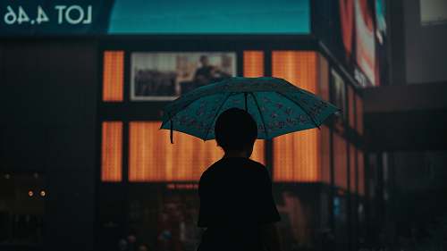 human silhouette of person under umbrella umbrella