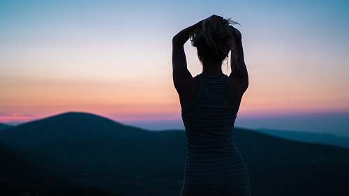people silhouette of woman standing near mountain peak woman