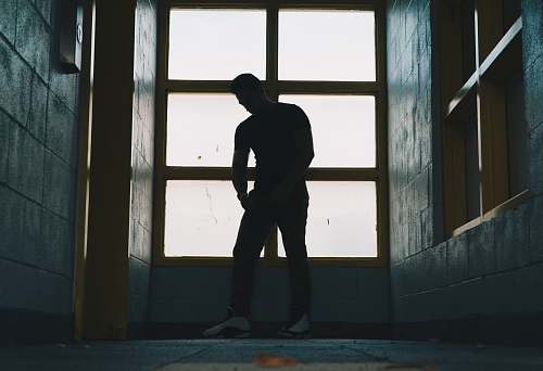 people silhouette photo of a man standing near glass window human