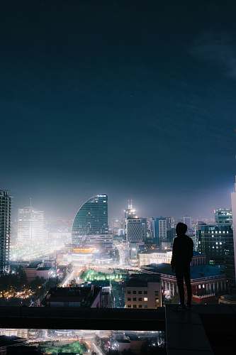 human silhouette photo of a person on the top of a building people