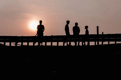 water silhouette photography of four people waterfront