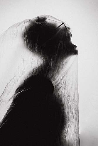black macro photography of person wrapped with clear plastic bag halloween