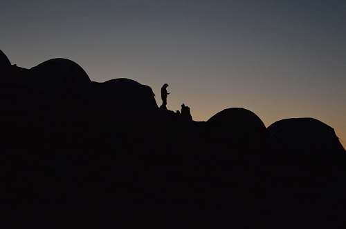 dusk A silhouette of a person in a camping site on a slope at night sunrise