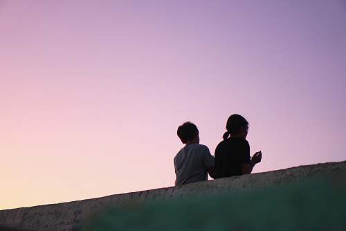 human girl and boy lean on concrete hand rail person