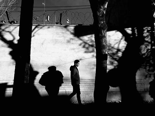 human grayscale photo of man wearing hoodie black-and-white