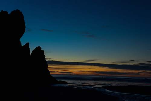 nature landscape photography of rock formation near body of water during nightime ruby beach
