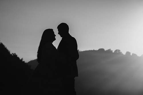human man and woman near mountain black-and-white