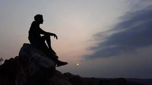human man sitting on stone person
