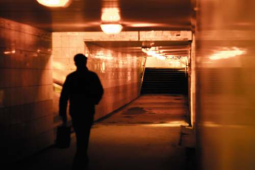 person man walking inside building with stair underground