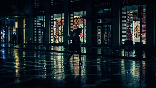 human person with umbrella walking beside building during nighttime person
