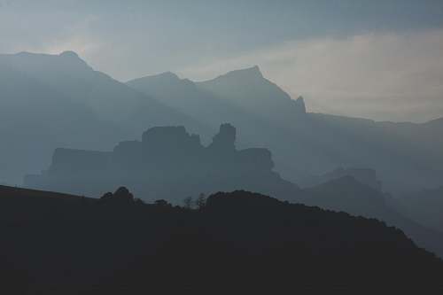 grey photo of foggy mountains during daytime mountain