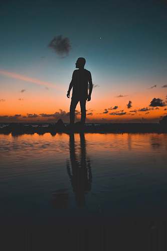 human photo of man standing near body of water outdoors