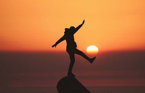 asilah photo of silhouette photo of man standing on rock morocco