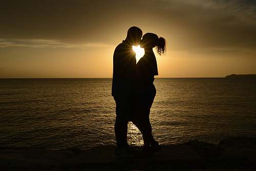 sunlight silhouette couple kissing against the sun couple
