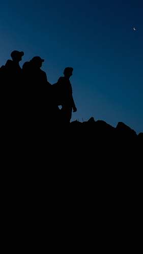 human silhouette of 3 person across night sky person