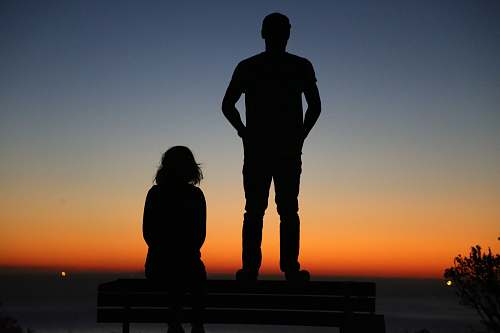 human silhouette of an standing man and sitting woman on bench people