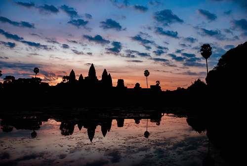 nature silhouette of building under cloudy sky during golden hour outdoors