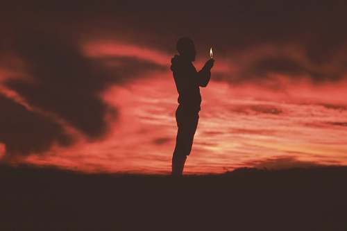 person silhouette of man holding lighter people