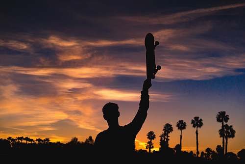 person silhouette of man holding skateboard human