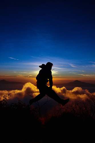 human silhouette of man jumping on mid air person