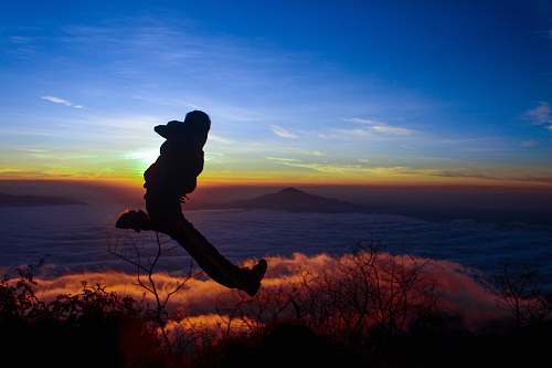 nature silhouette of man jumping on mid air outdoors