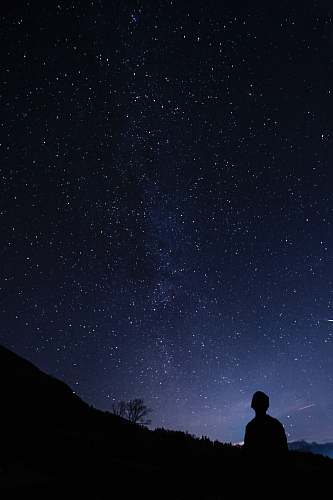 person silhouette of man looking at milky way space