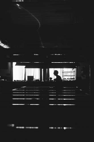 human silhouette of man near window black-and-white