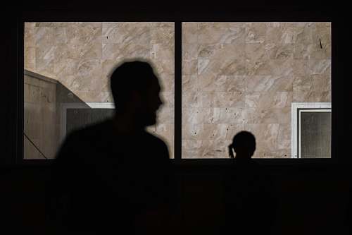 human silhouette of man standing beside window person