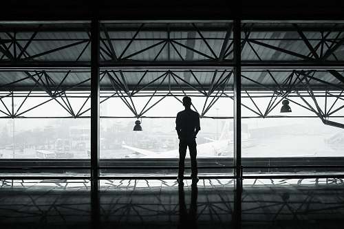 person silhouette of man standing between two posts building