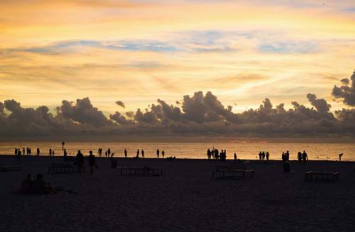 sunset silhouette of people on the beach dusk