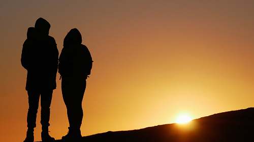 human silhouette of people on top of hill during sunset people