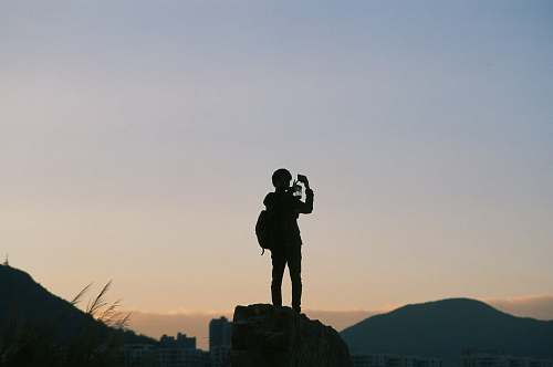 human silhouette of people standing on peak person