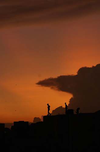 nature silhouette of people standing on rooftop outdoors