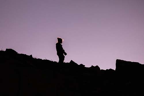 human silhouette of person holding DSLR camera person