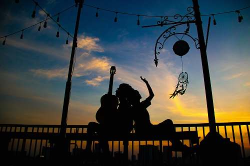 human silhouette of person holding guitar person