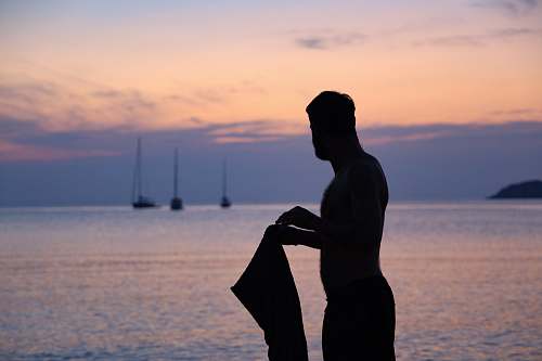 human silhouette of person holding tops boat