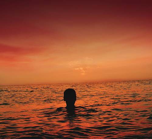 morocco silhouette of person in ocean during sunset orange