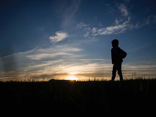 nature silhouette of person standing on grass field sky