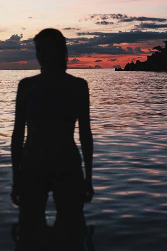 nature silhouette of person standing on water sky
