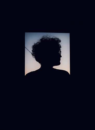 indoors silhouette of person with curly hair and eyeglasses interior design