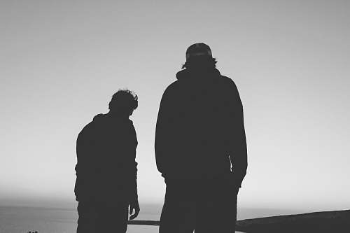 black-and-white silhouette of two man grey