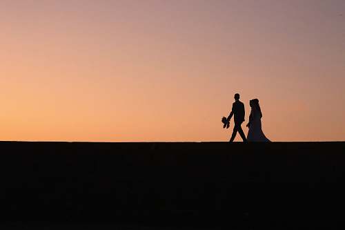 person silhouette of two people during golden hour human