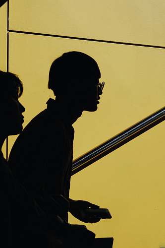 yellow silhouette of two person against yellow background man