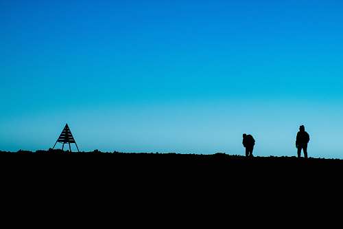blue silhouette of two person standing on ground near tent at daytime morocco